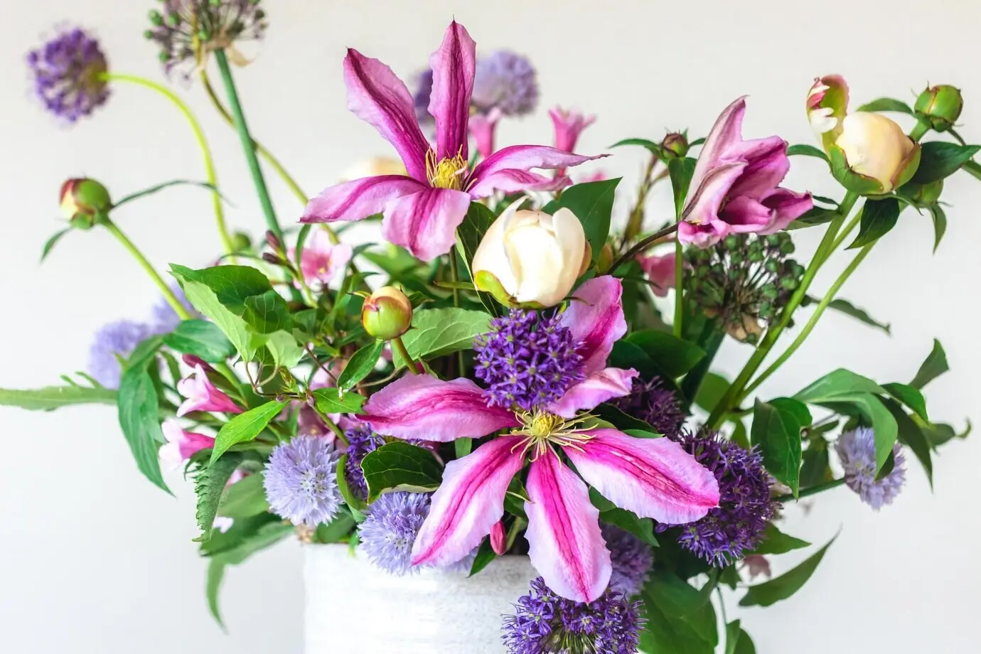 Blumen aus einem heimischen Garten in einer Vase vor weißem Hintergrund.